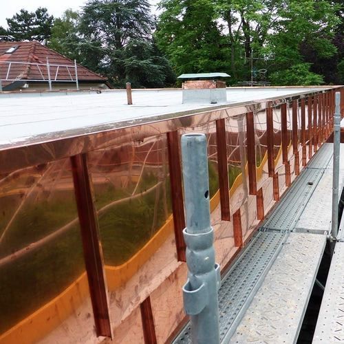 A copper wall is being built on the side of a building