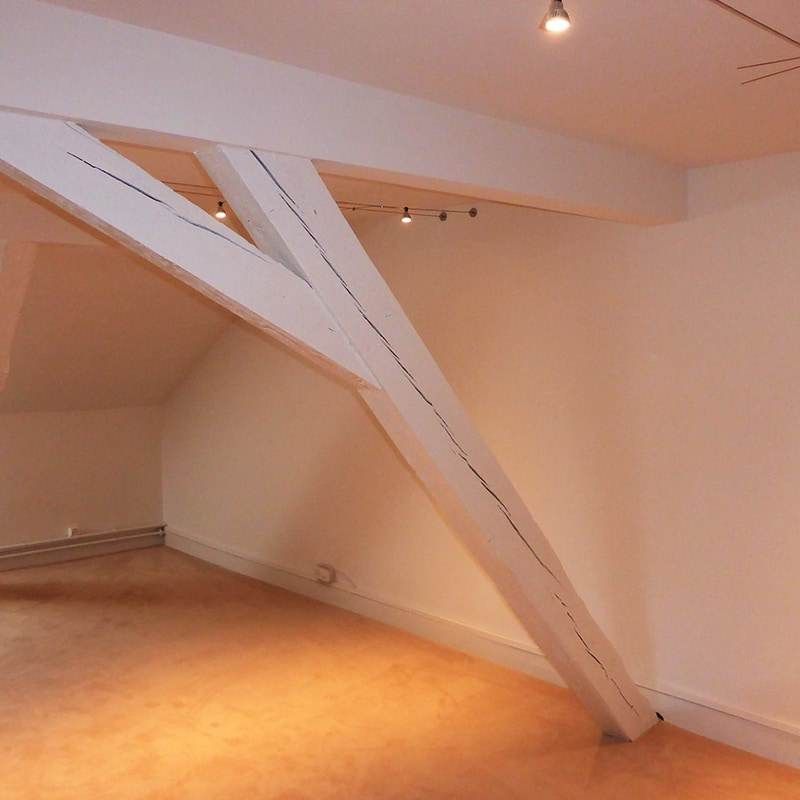 An empty room with a large white beam in the middle