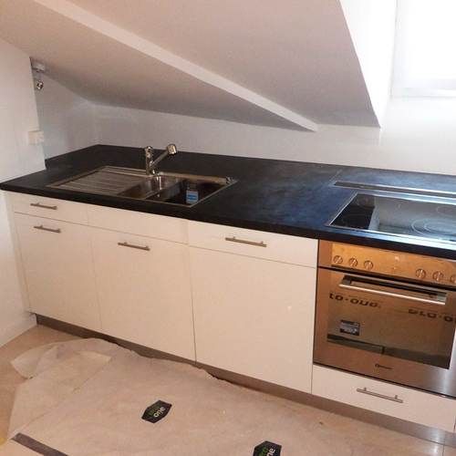A kitchen with a sink , stove , and oven.