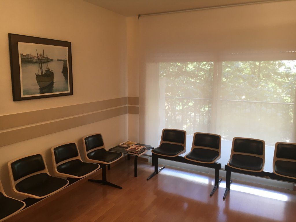 Una sala de espera con una imagen de un barco en la pared.