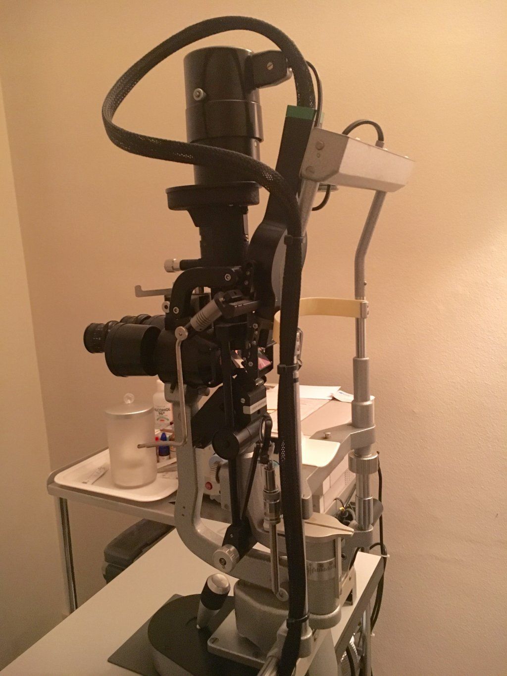 Un microscopio está sobre una mesa en una habitación.