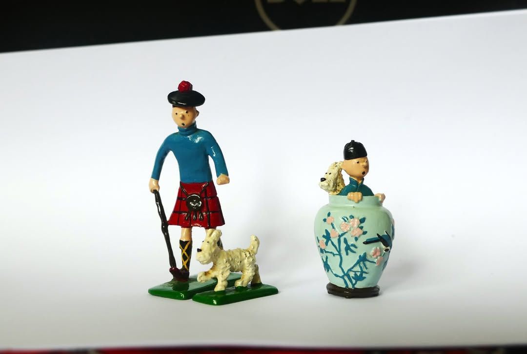 Petites figurines : un homme avec un chien, à côté d’un vase bleu avec une figure assise