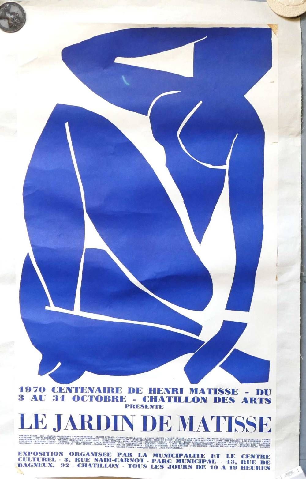 Affiche abstraite bleue en papier découpé, avec des lignes blanches et le texte « Le Jardin de Matisse » en bas.