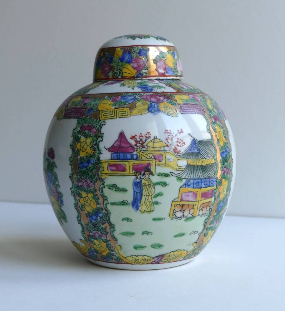 Pot décoratif en porcelaine, peint d’une scène de village colorée et orné d’une bordure florale