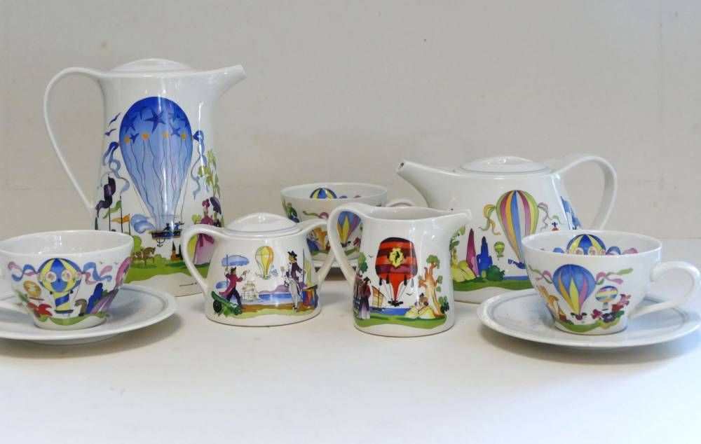 Service à thé décoratif en porcelaine, orné de motifs floraux bleus et de touches colorées.