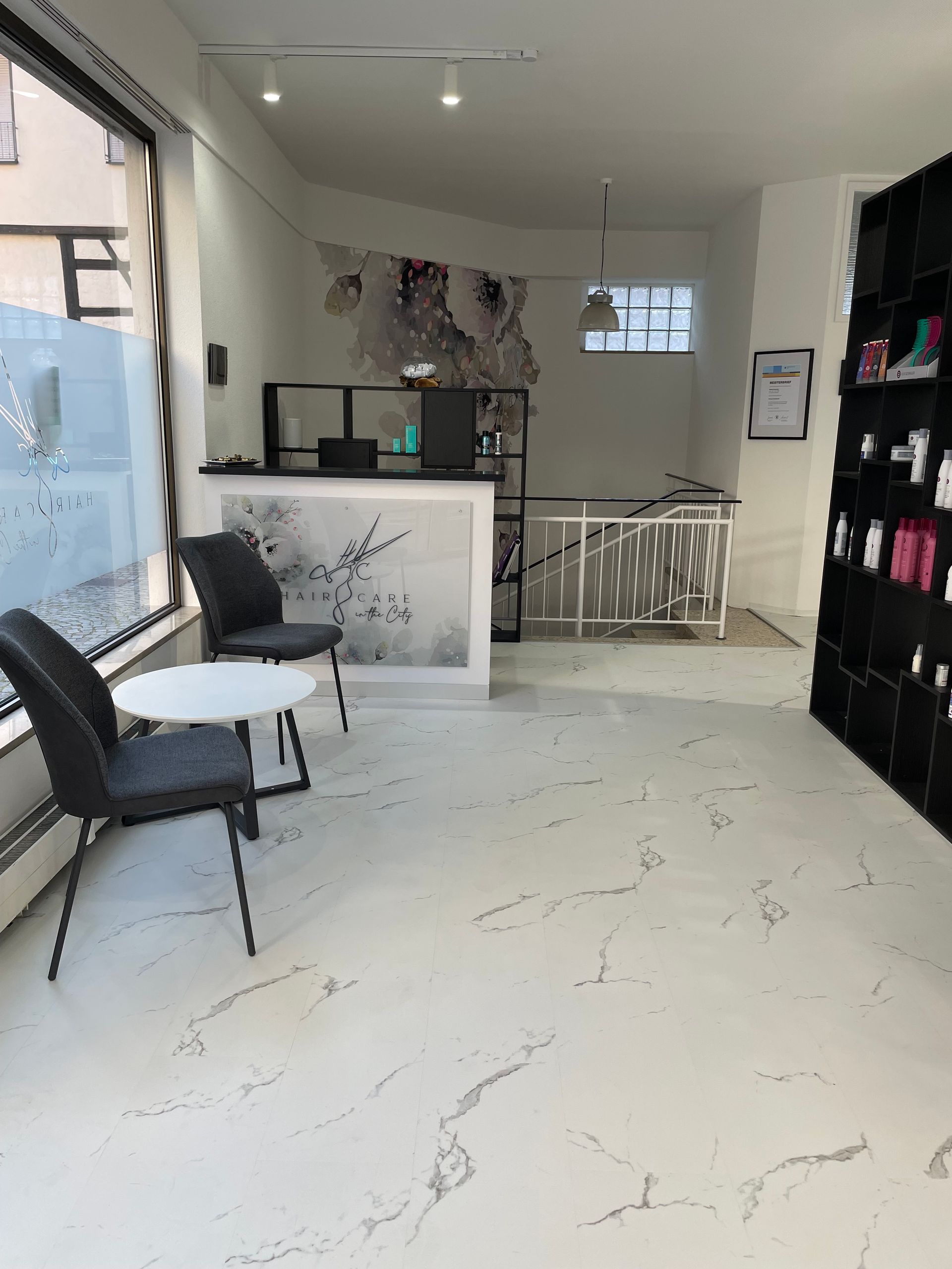 Im Zimmer befinden sich zwei Stühle und ein Tisch.