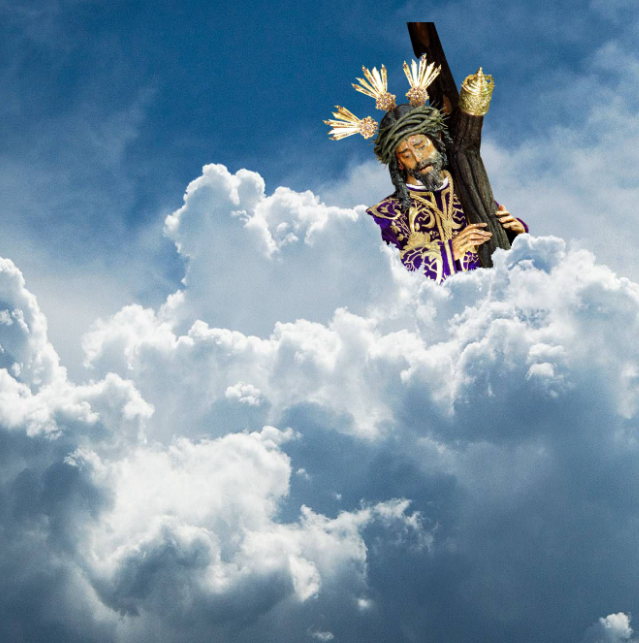 Una estatua de Jesús llevando una cruz en las nubes