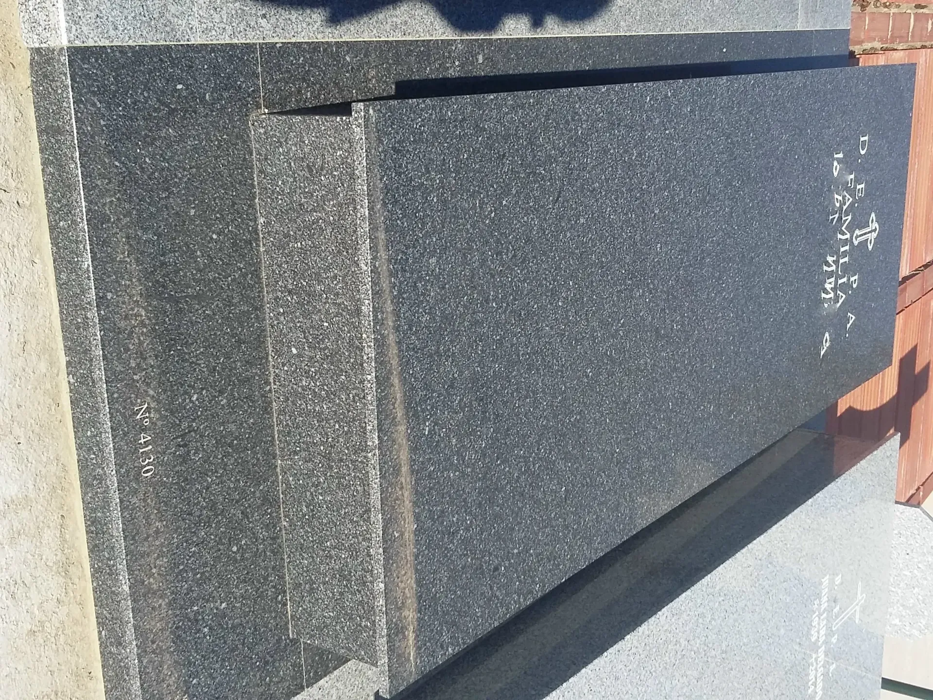 Una pared de granito negro con una sombra sobre ella.