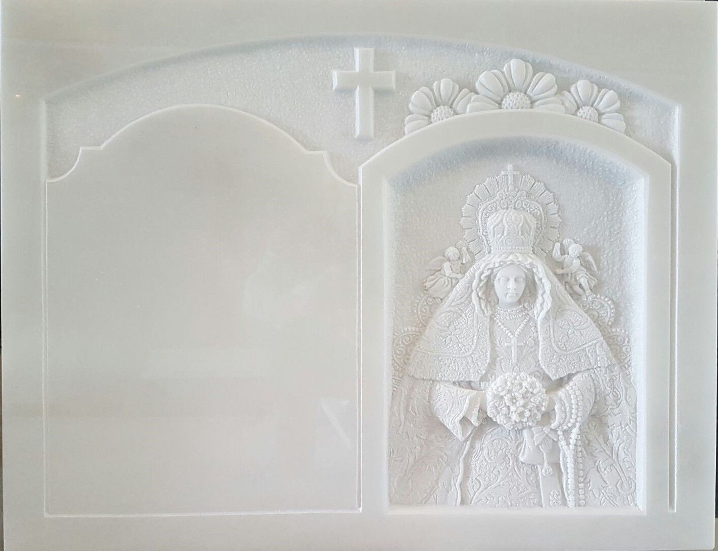 Una estatua blanca de una mujer con una cruz en la parte superior de su cabeza.