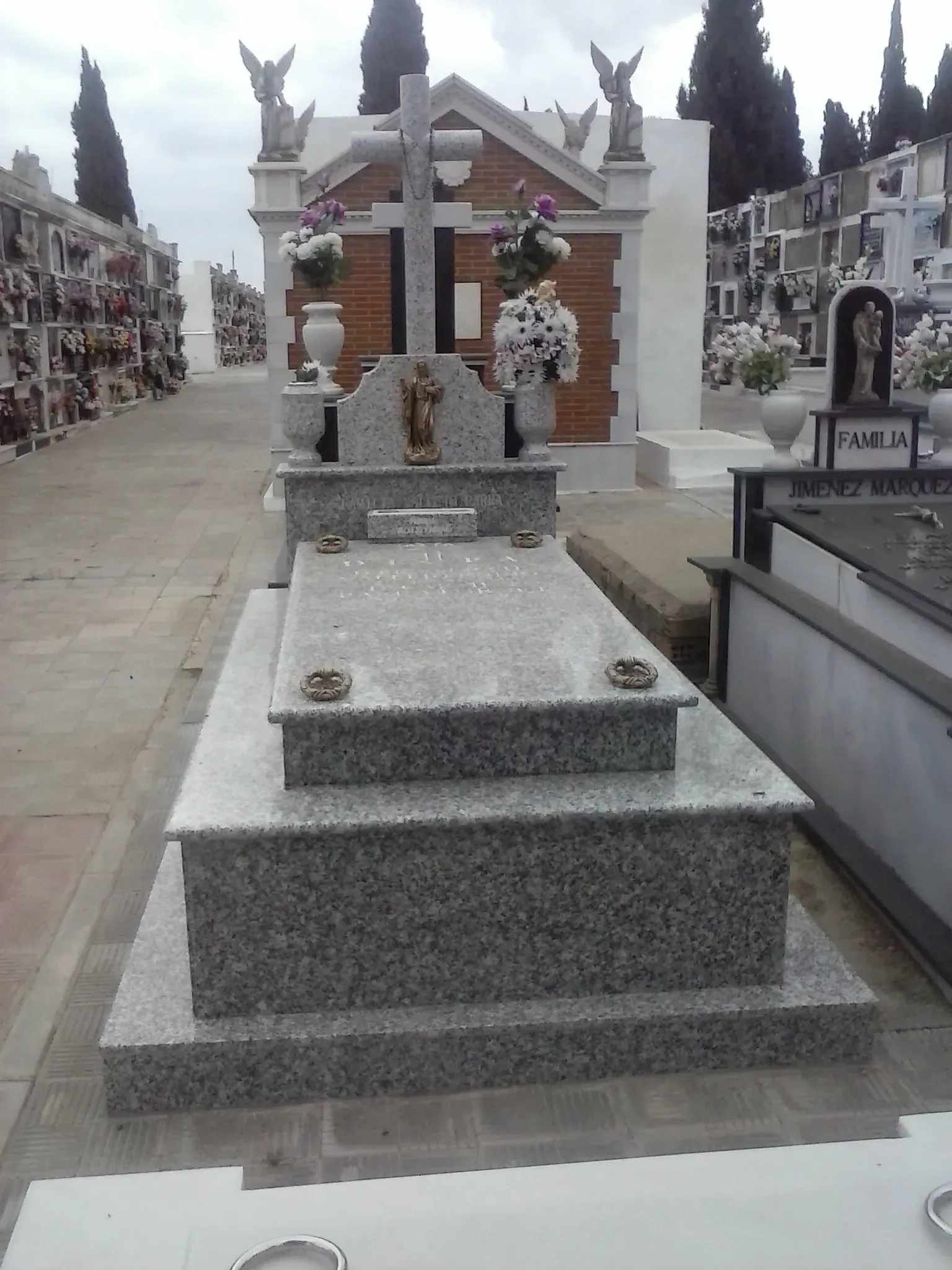 Una tumba en un cementerio con una cruz encima