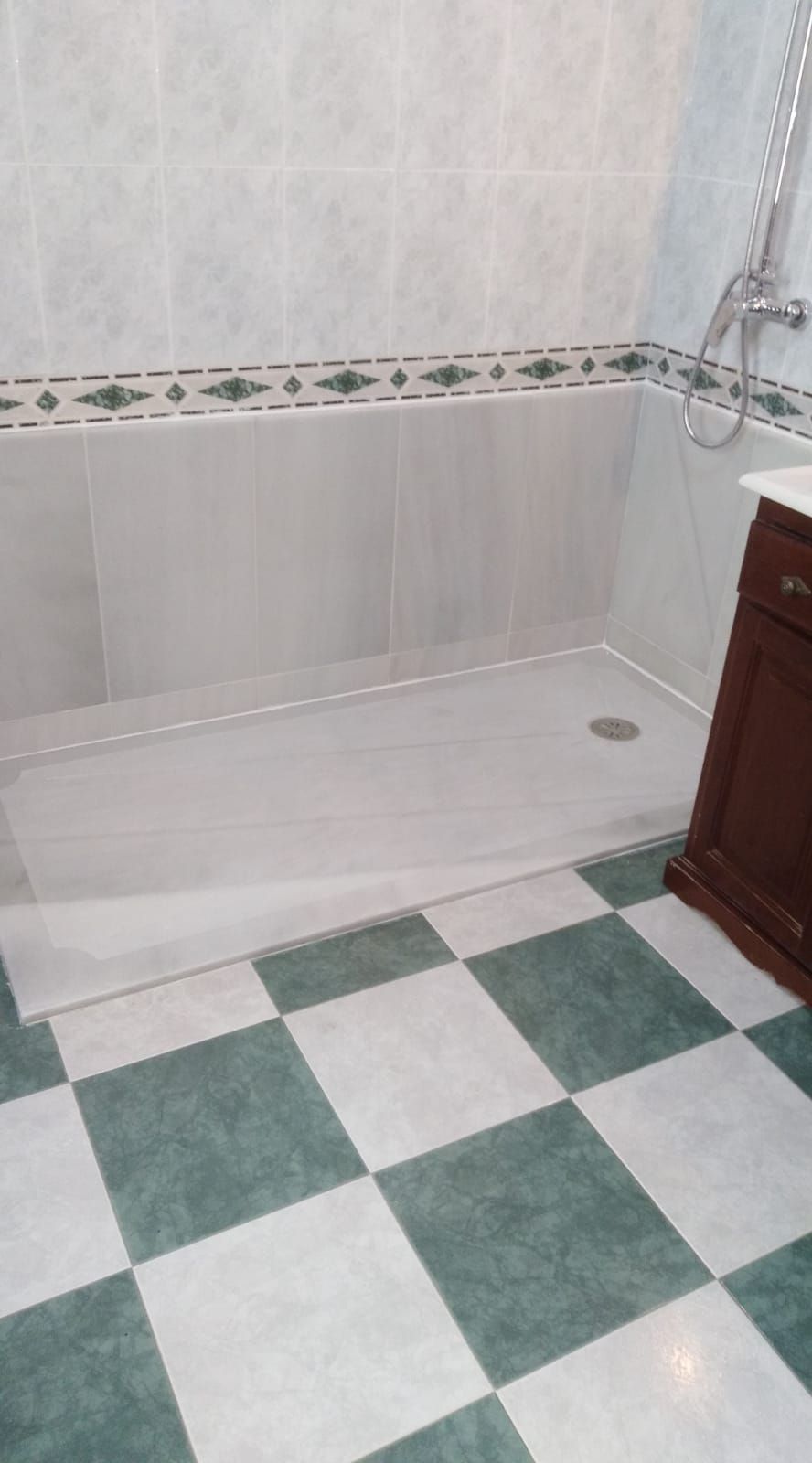 Un baño con bañera y suelo de cuadros.
