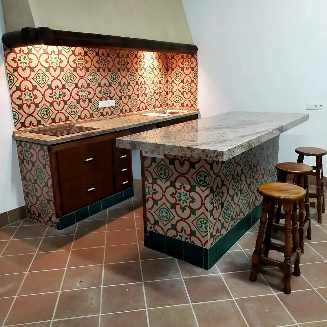 Una cocina con una mesa y taburetes.