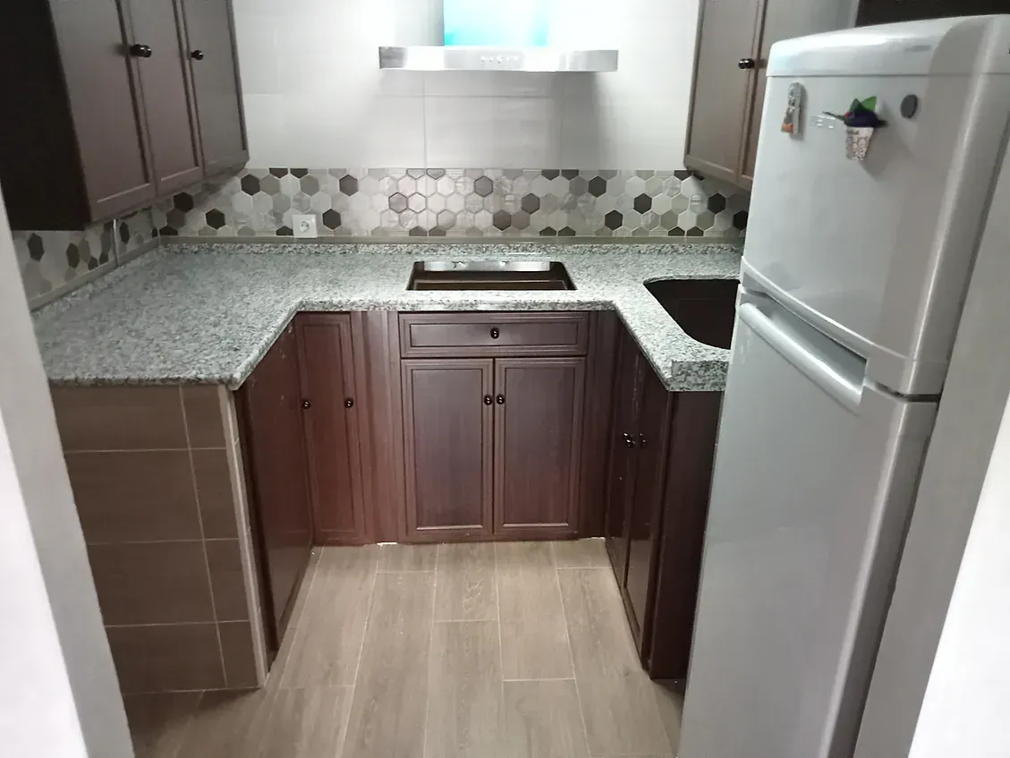Una cocina con frigorífico y fregadero