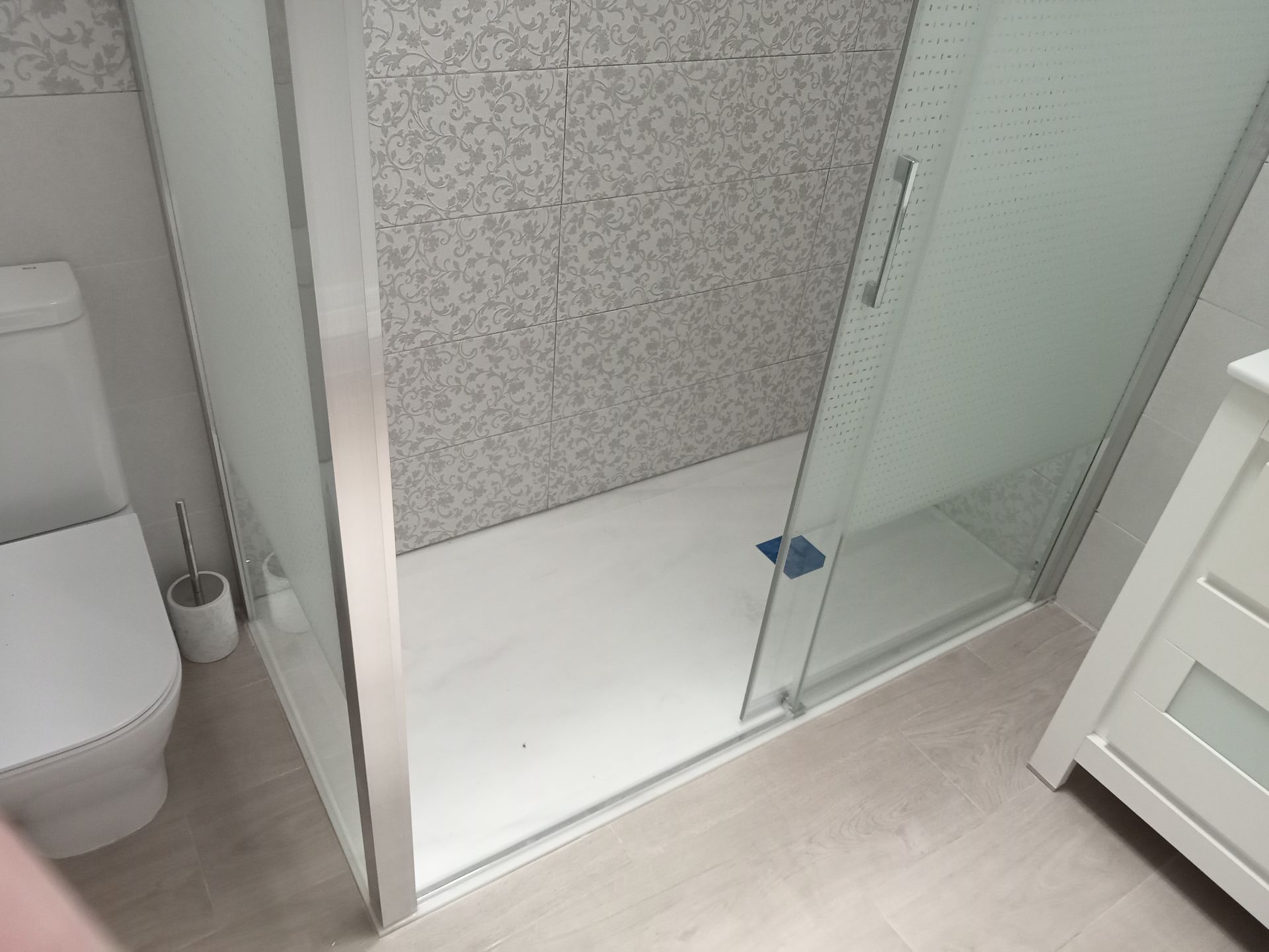 Un baño con inodoro, lavabo y ducha.