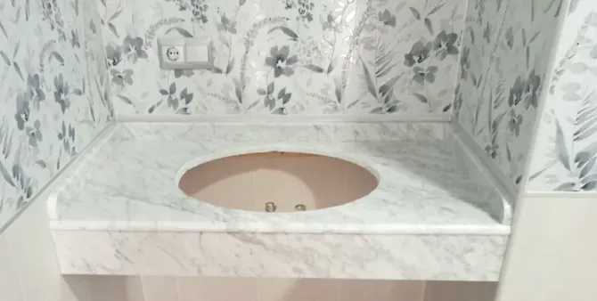Un lavabo de baño con encimera de mármol y grifo.