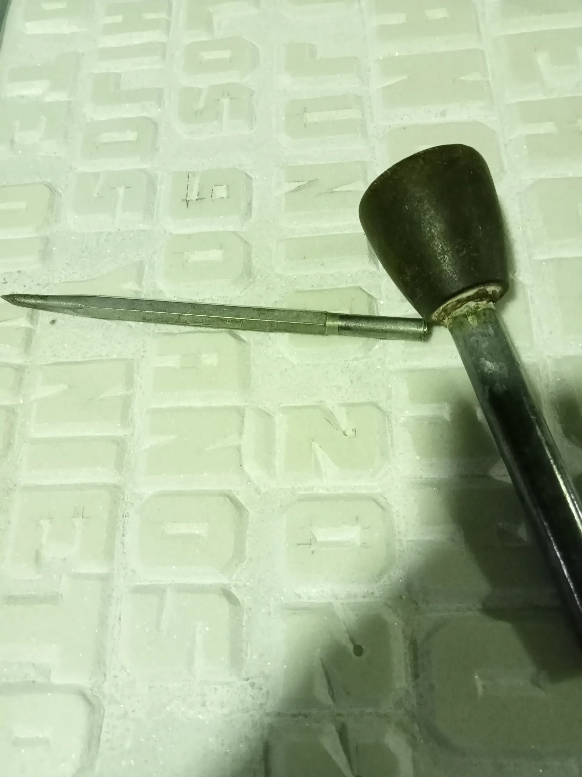 Un primer plano de un destornillador sobre una superficie blanca.