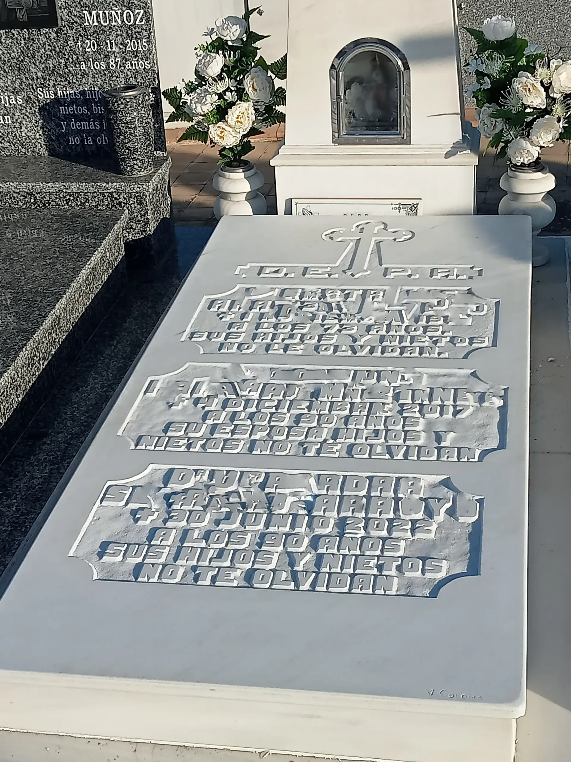 Una tumba en un cementerio con flores.