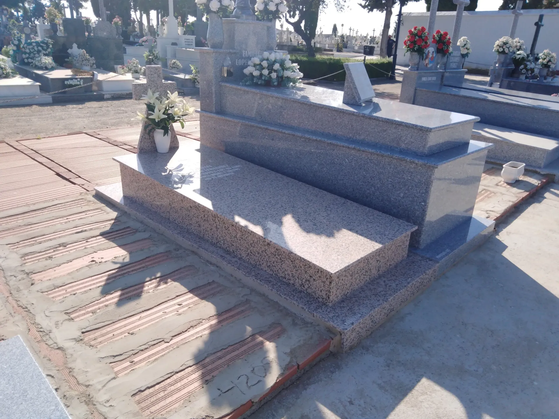 Una tumba con flores en un cementerio.