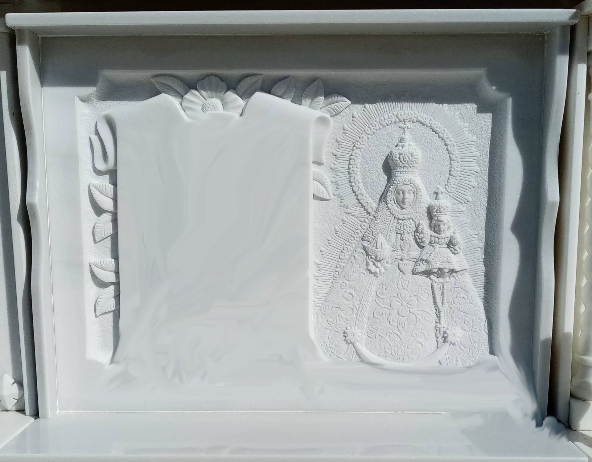 Una placa de mármol blanco con una imagen de Jesús en ella.