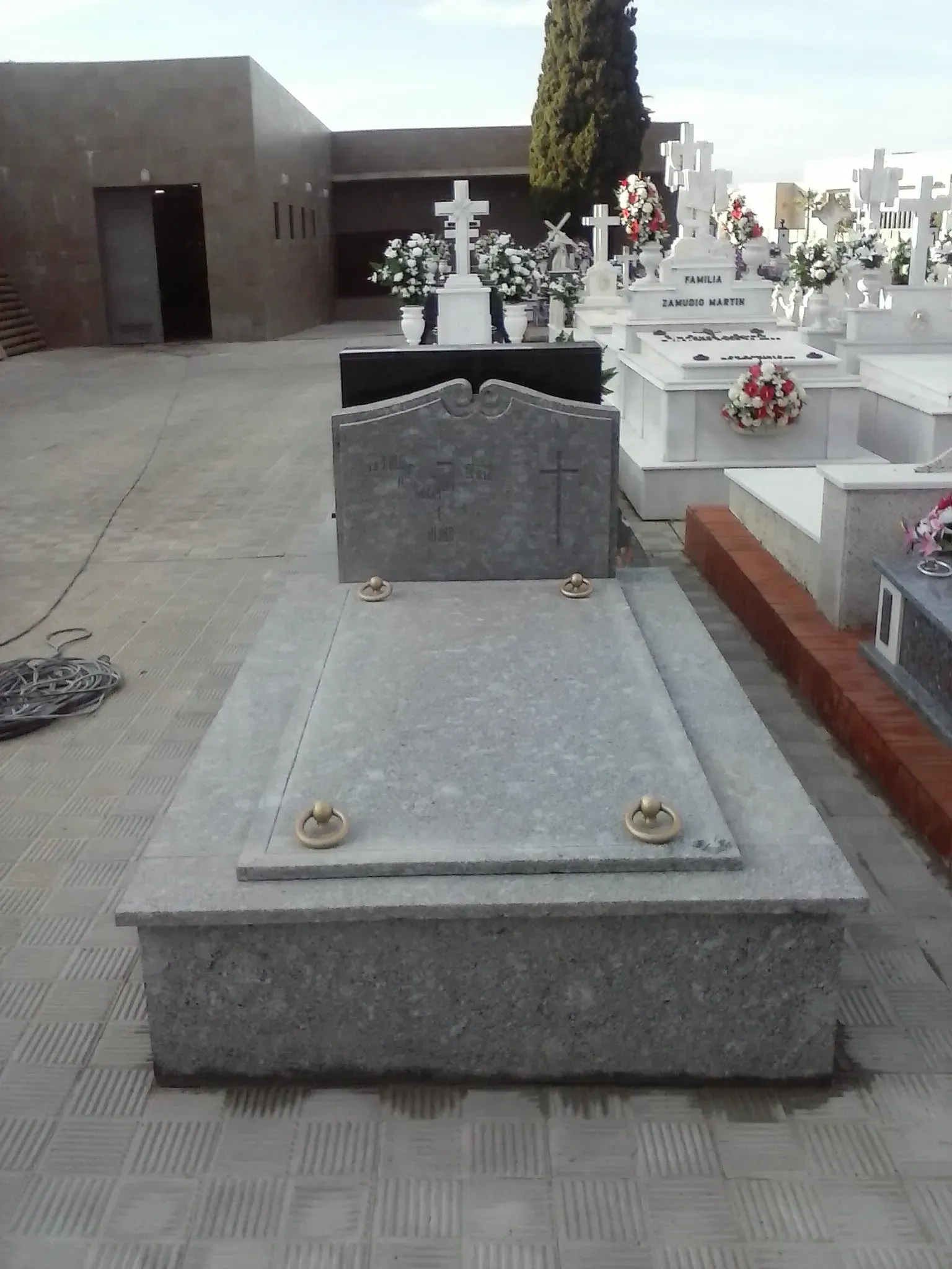 Una tumba en un cementerio con flores.