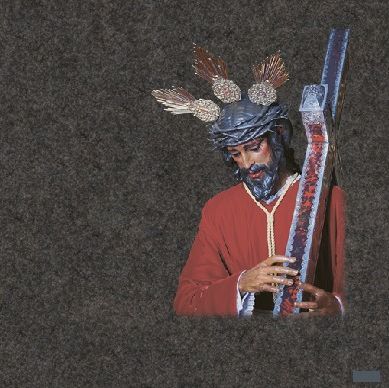 Una estatua de Jesús con una corona de espinas sosteniendo una cruz.