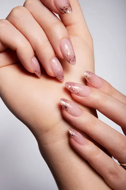 Un primer plano de la mano de una mujer con uñas largas.