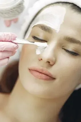 Una mujer está recibiendo un tratamiento facial en un spa.