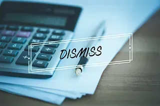 Calculadora y bolígrafo sobre papel con superposición de “DESCARTAR”.