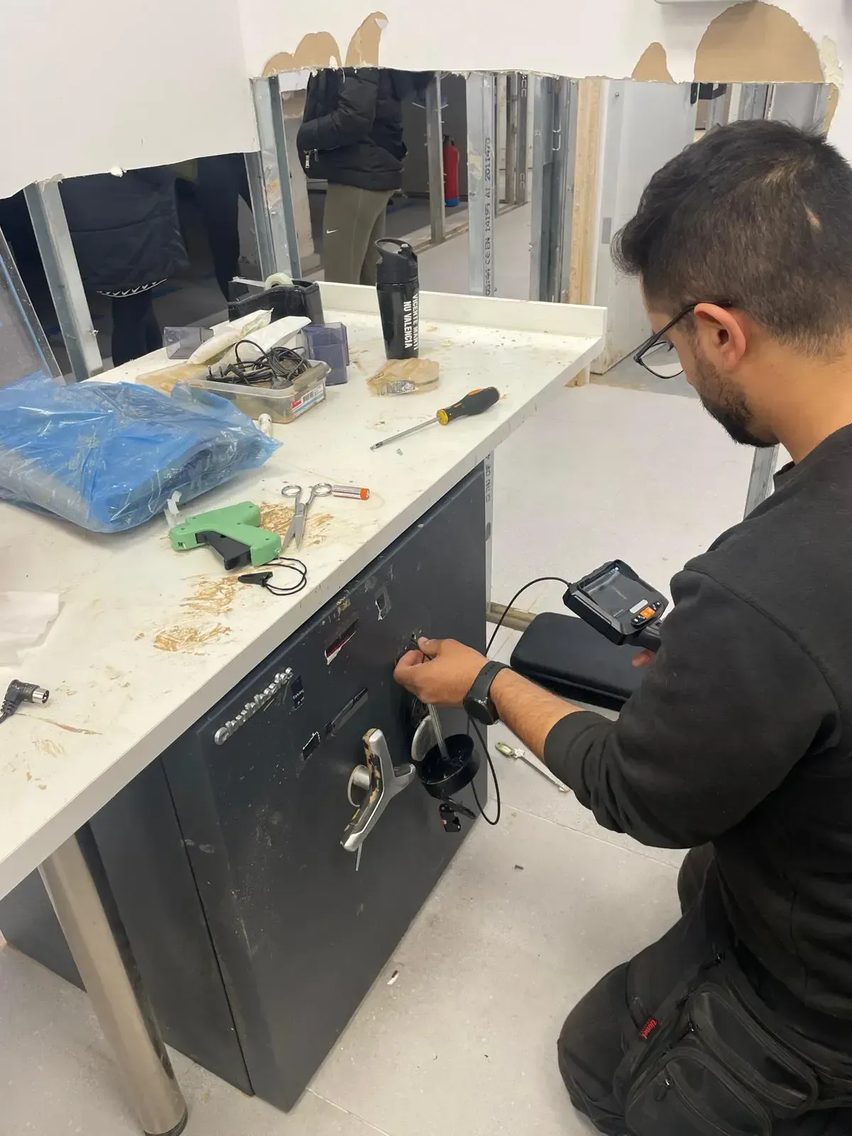 Persona trabajando en una caja fuerte en una habitación. 