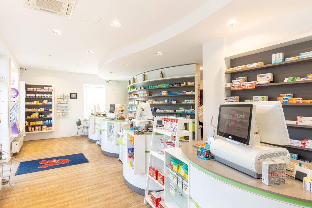 Das Innere einer Apotheke mit vielen Regalen und einer Theke.