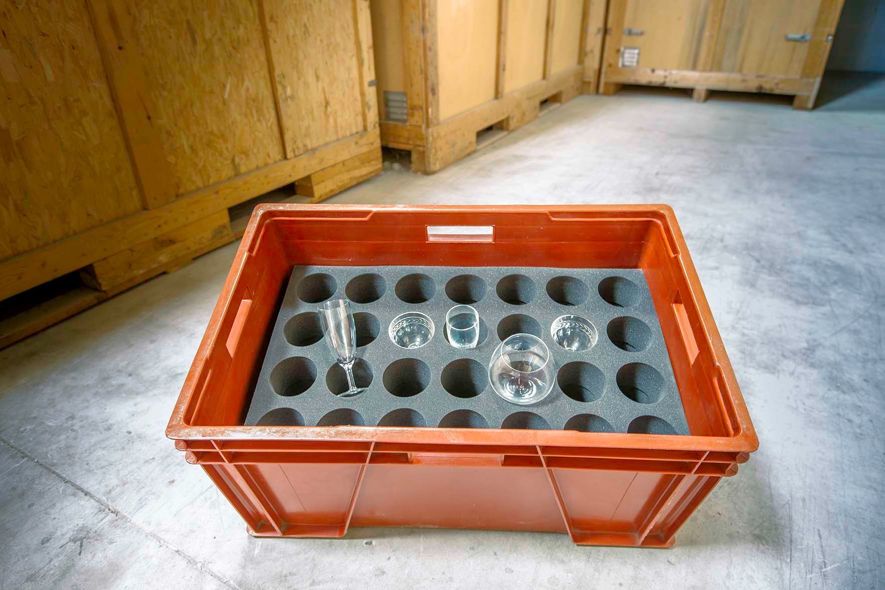 Verres de différents types posés dans de la mousse de protection, dans une caisse