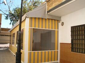 Un toldo de rayas amarillas y blancas está en el costado de un edificio.