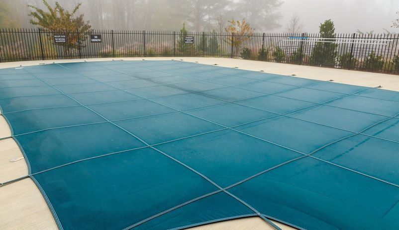 Una gran piscina con una cubierta azul.