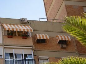 Un edificio con un toldo a rayas en el costado.