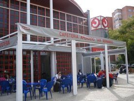 Una cafetería con mesas y sillas en el exterior.