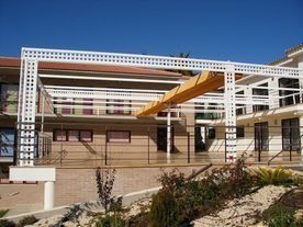 Un gran edificio blanco con un balcón en el costado.