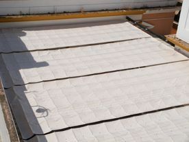 Un techo con muchas tejas y una sombra sobre él.