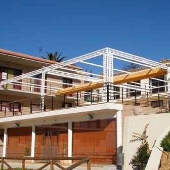 Un edificio grande con un balcón y una valla delante.