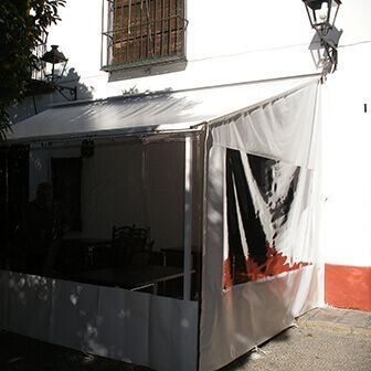 Una carpa blanca está afuera de un edificio blanco