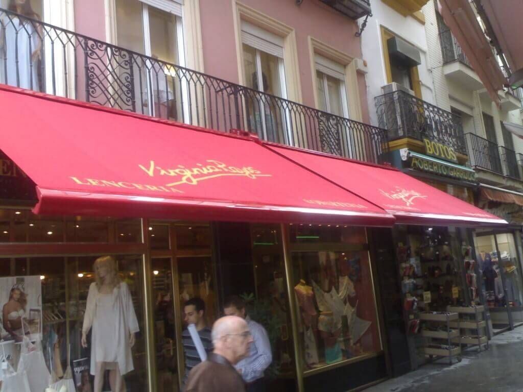 Una tienda con un toldo rojo que dice