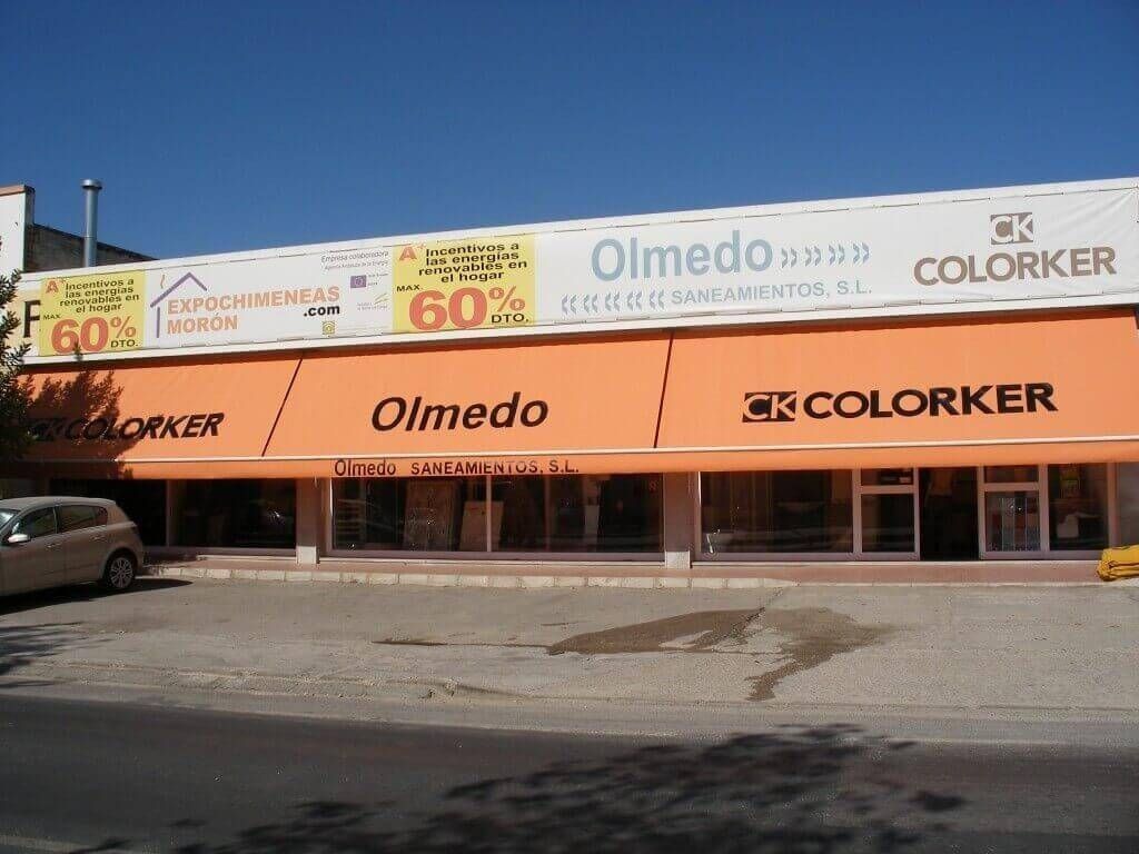 Una tienda con un toldo naranja que dice Olmedo