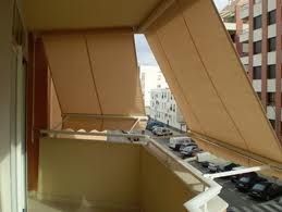 Un balcón con dosel y vista a una ciudad.