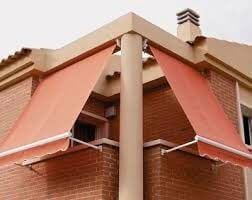 Un edificio de ladrillo con un toldo rojo en el costado.