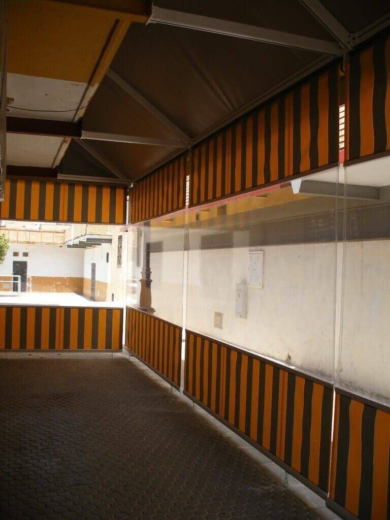 Un largo pasillo con toldos a rayas en las paredes.