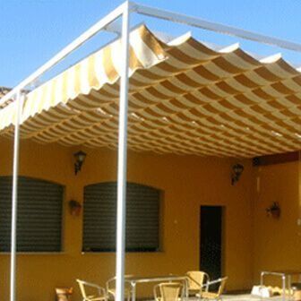 Un patio con mesas y sillas bajo un dosel.