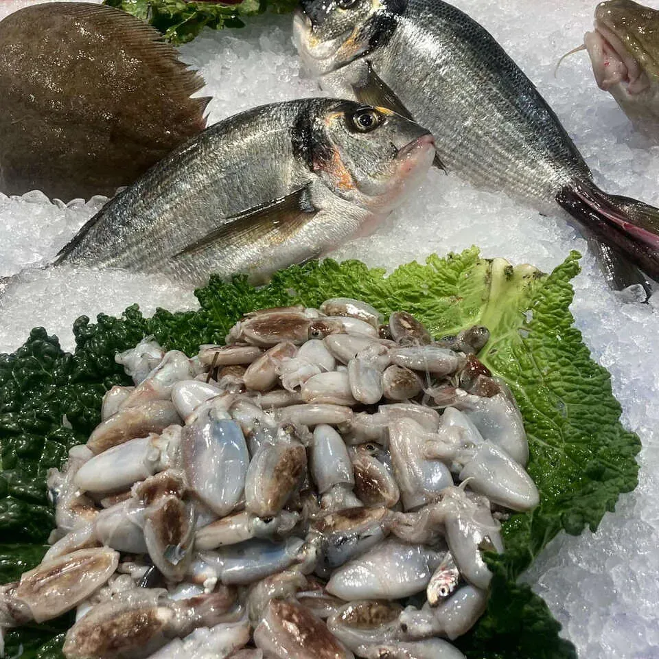 Una variedad de mariscos, incluyendo pescado y calamares en hielo.