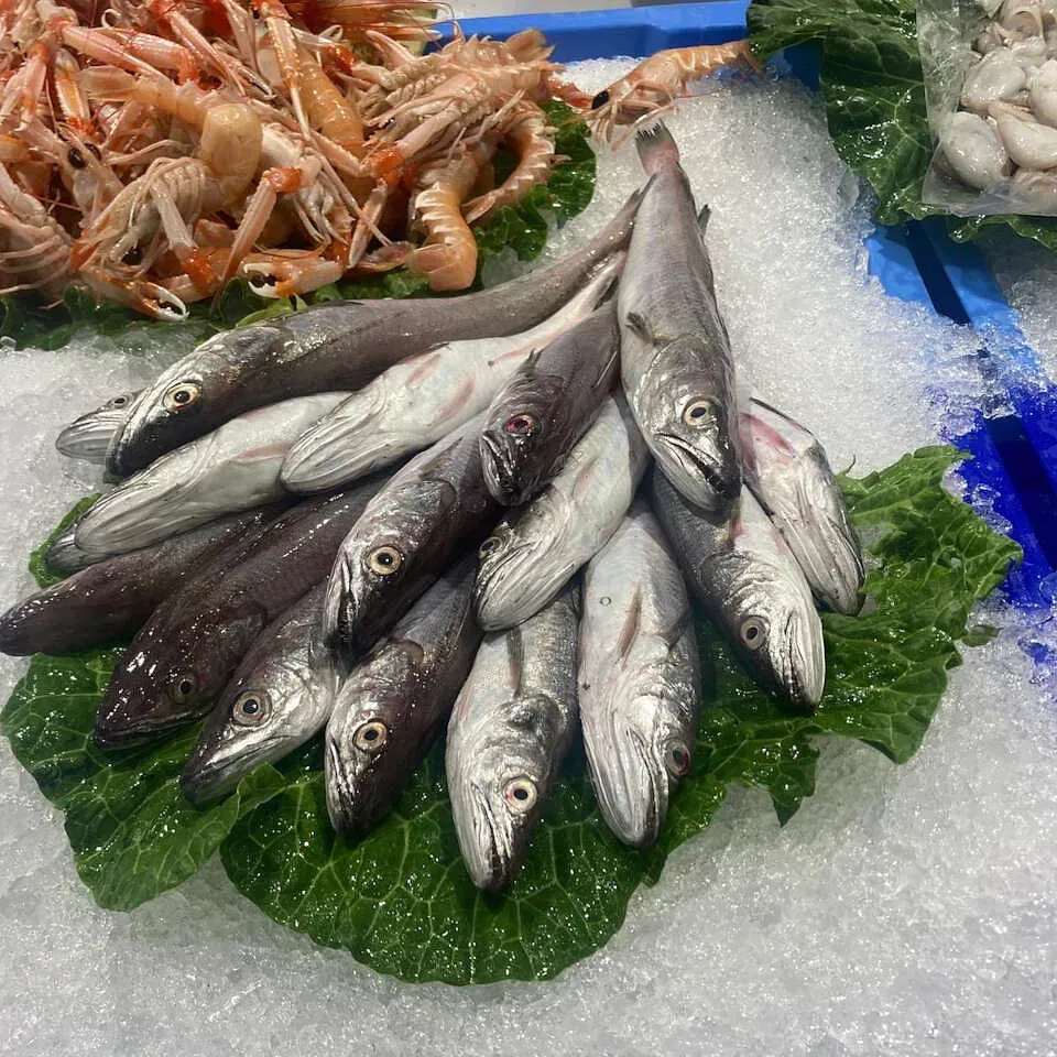 Un montón de peces están sentados encima de una hoja de lechuga sobre hielo.