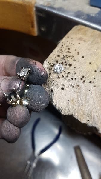 Una persona sostiene un par de pendientes en su mano.