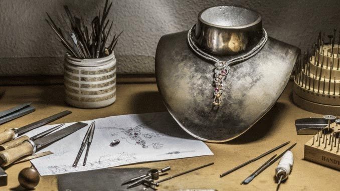 Un collar está sobre un maniquí sobre una mesa rodeado de herramientas.