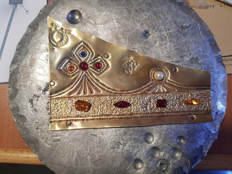 Una placa de plata con un diseño de corona.